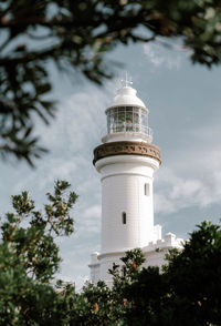 Low angle view of lighthouse by building against sky