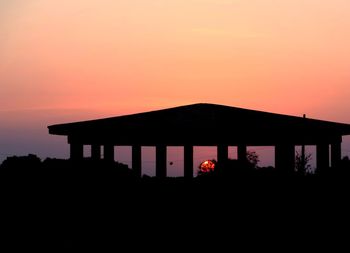 Silhouette house against clear sky at sunset