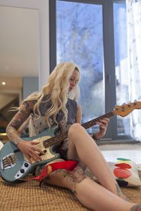 Beautiful young woman playing an electric guitar