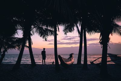 Silhouette person on beach against sky during sunset