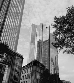 Low angle view of deutsche bank twin towers against cloudy sky