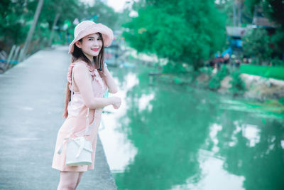 Portrait of smiling young woman standing in water