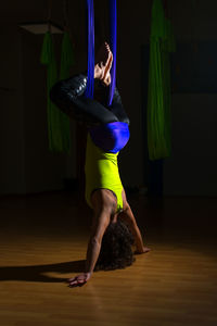 Full length of woman exercising on wooden floor