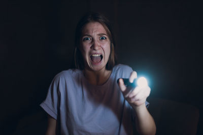 Portrait of young woman holding sparkler at home