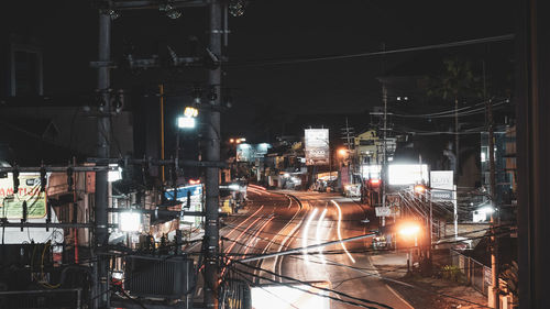 Train on illuminated railroad tracks in city at night