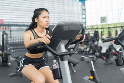 Young woman exercise bike at gym