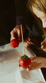 Friends holding lollipop and cell phone at table