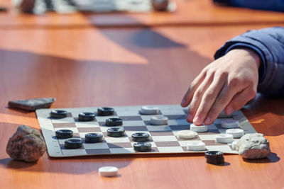 Cropped hand of man playing chess