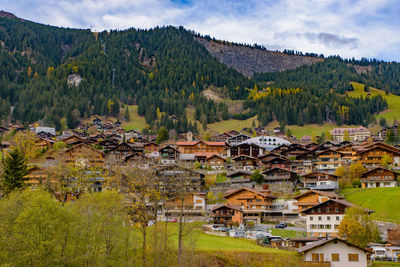 Scenic view of townscape and mountains against sky