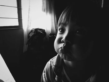 Close-up portrait of cute boy looking away at home