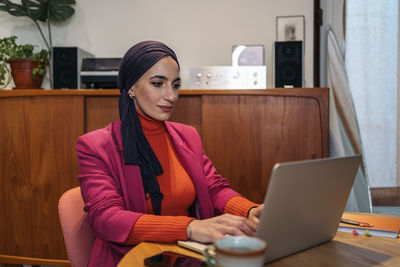 Young woman using laptop at home