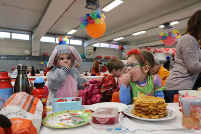 Children having food at table in school