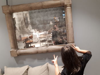 Rear view of woman relaxing on wall