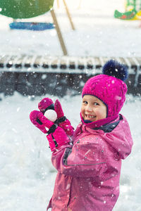Portrait of cute smiling girl enjoying on snow