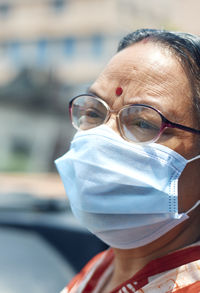 Portrait of an aged indian woman wearing surgical face mask due to covid-19 pandemic.