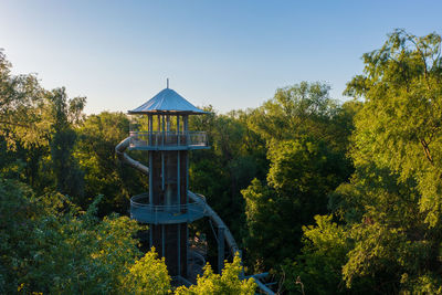 Gazebo amidst trees against clear blue sky