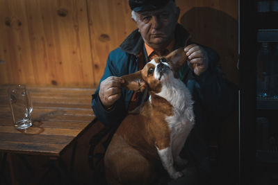 Close-up portrait of man with dog sitting on table
