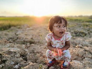 Portrait of cute girl sitting on land