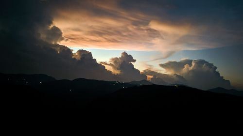 Scenic view of silhouette mountains against dramatic sky