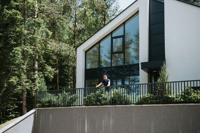 Man standing by railing against building