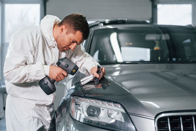 Professional worker. man in uniform is in the auto service.