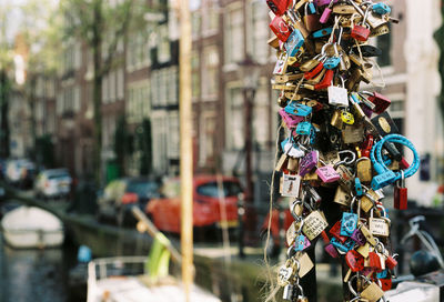 Close-up of colorful tangled padlocks against building in city