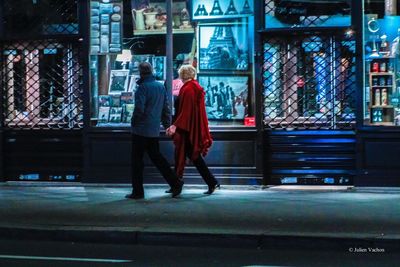 Full length of friends standing on illuminated city at night