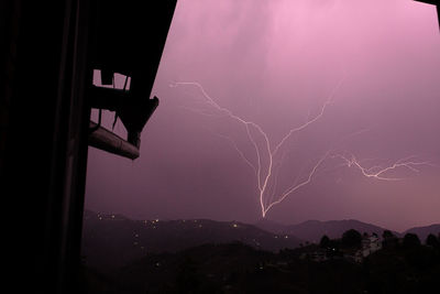 Low angle view of lightning in sky over city at night