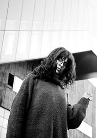 Portrait of woman standing against wall