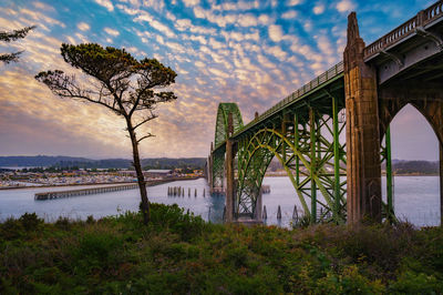 Bridge over river against sky during sunset