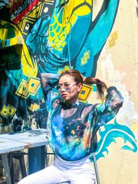 Woman standing against graffiti wall