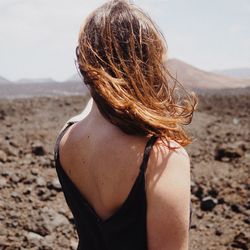 Rear view of woman sitting at beach
