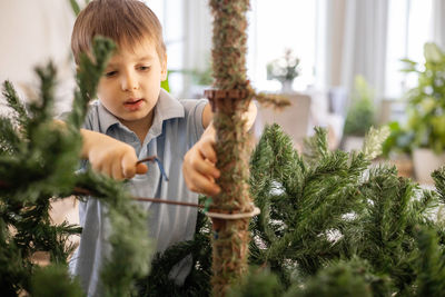 Close-up of boy standing against trees