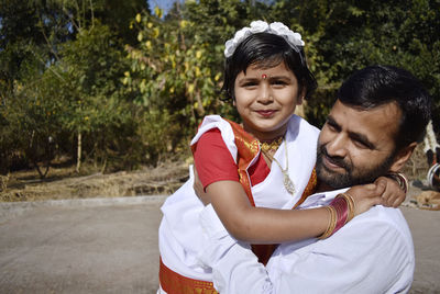 Portrait of father and daughter against trees