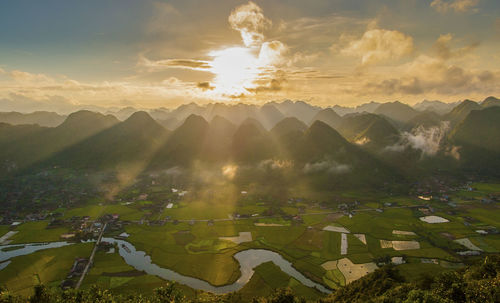 Scenic view of field against sky at sunset