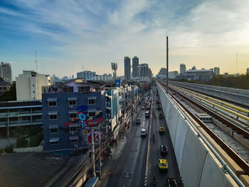 High angle view of railroad tracks by buildings in city against sky