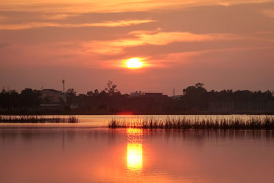 Scenic view of lake against orange sky