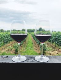 Close-up of wine glasses on table against sky