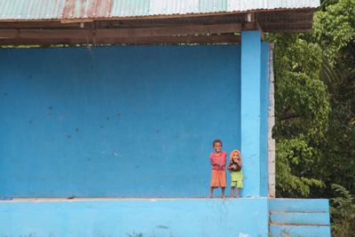 People standing against blue wall