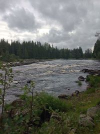 Scenic view of lake against cloudy sky