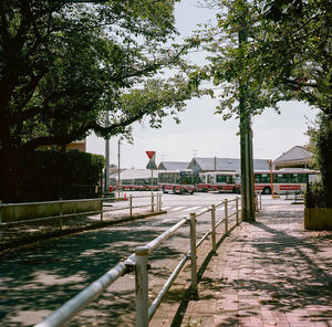 Footpath by street and buildings against sky