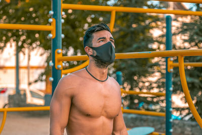 Athletic male exercising chin-ups in playground