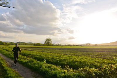 Rear view of woman walking on field