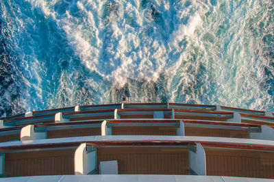 Empty chairs by sea against sky