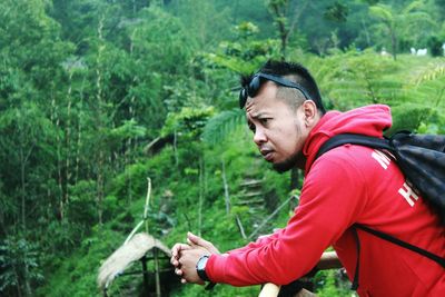 Side view of young man looking away in forest