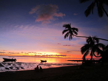 Silhouette of palm trees at sunset