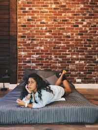 Portrait of young woman relaxing on bed at home 