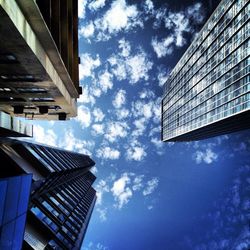 Low angle view of modern building against cloudy sky