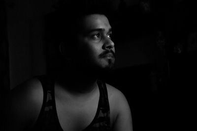 Thoughtful young man sitting in darkroom