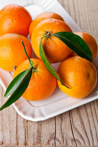 Close-up of oranges in plate on table